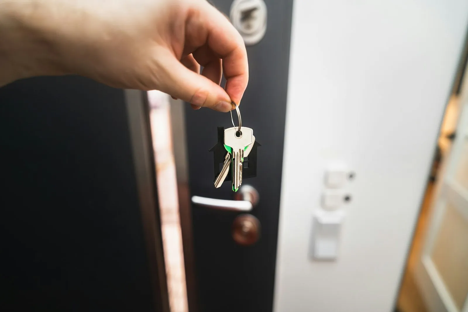 Person holding a key at a door