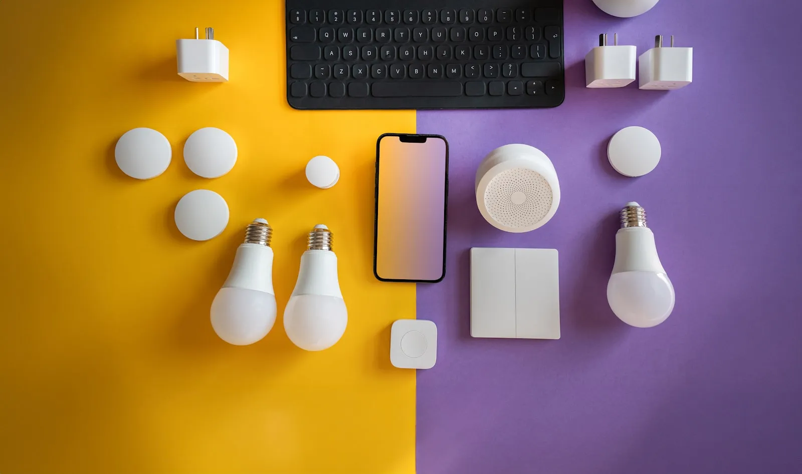 Smart home gadgets including a keyboard and light bulbs laid out flat